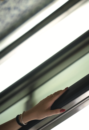 Frauenhand mit Schmuck und Nagellack auf Fensterrahmen